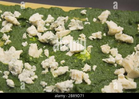 Spinat und schimmeliger Käse auf roher Lasagna Pasta in Backblech Stockfoto