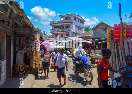 Soanierana Ivongo, Madagaskar, Afrika 01/08/20: Afrikanische Schwarze auf dem Weg in die chaotische und staubige Straße einer kleinen Küstenstadt, bunt entspannen Stockfoto