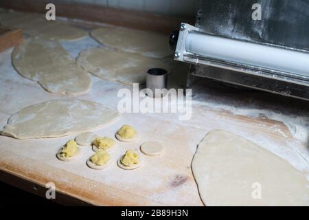 Frau, die ukrainische Knödel mit Kartoffeln und Hüttenkäse anstellt Stockfoto