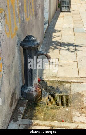 Öffentlicher Wasserhahn aus alter Bronze für frisches Wasser. Traditioneller Trinkwasser-Brunnen Venedig Italien. Stockfoto