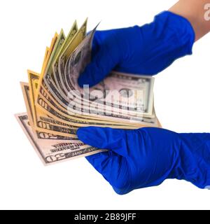 Hände in medizinischen Handschuhen, die ein Bündel von Dollar enthalten. Das Konzept der Geldinfektion, des schmutzigen Geldes, der bezahlten Medikamente, der Behandlungsgebühren, der Bestechung, der illegalen Operation. Stockfoto