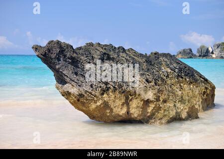 Große Steintextur ganz in der Nähe mit türkisfarbenem Meer und blauem Himmel am Pink Beach, Bermuda. Stockfoto