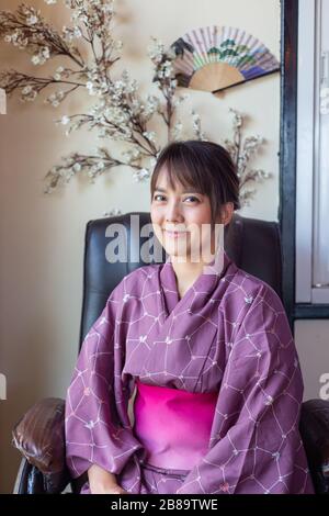 Das Mädchen trägt eine rosafarbene traditionelle Yukata, die das nationale Kleid Japans ist Stockfoto