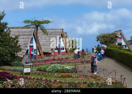 Santana, Madeira - März 2020: Touristen, die die traditionellen Häuser in Santana besuchen. Insel Madeira, Portugal Stockfoto