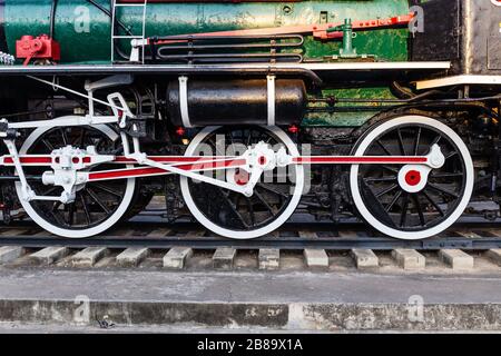 Alte Zugräder auf Schienen in schwarz, rot und weiß. Stockfoto