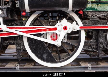Alte Zugräder auf Schienen in schwarz, rot und weiß. Stockfoto