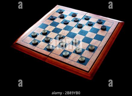 Auf einem Holzscheckbard sind runde Holzschachbrettfächer angelegt, die für jemanden bereit sind, ein Spiel zu spielen Stockfoto