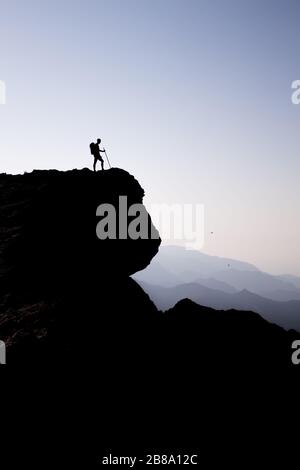 Mann, der auf dem Berg in der Nähe der Klippe wandert. Stockfoto