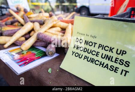 Farmers Market in Los Angeles, März 2020: Schilder mit Sicherheitshinweisen, die die Menschen dazu drängen, Abstand zu halten und nur Produkte zu holen, die sie kaufen möchten, Los an Stockfoto