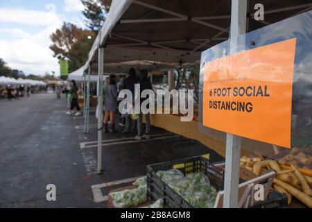 Farmers Market in Los Angeles, März 2020: Schilder mit Sicherheitshinweisen, die die Menschen dazu drängen, Abstand zu halten und nur Produkte zu holen, die sie kaufen möchten, Los an Stockfoto