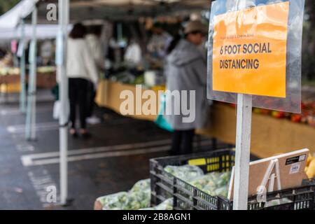 Farmers Market in Los Angeles, März 2020: Schilder mit Sicherheitshinweisen, die die Menschen dazu drängen, Abstand zu halten und nur Produkte zu holen, die sie kaufen möchten, Los an Stockfoto