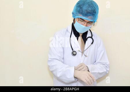 Ein junger Arzt in Uniform mit Maske und Handschuhen Stockfoto