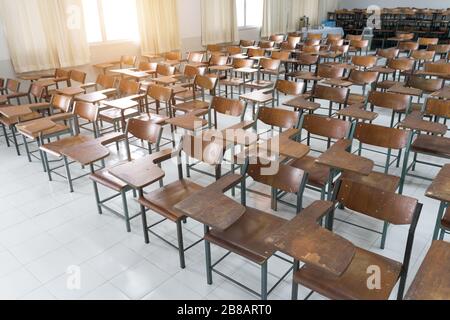 Leeres Klassenzimmer mit vielen Stühlen ohne Schüler. Leeres Klassenzimmer mit Holzstühlen in Vintage-Ton. Zurück zum Schulkonzept. Stockfoto