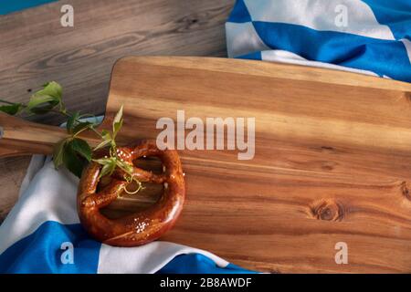 Ein traditionelles deutsches Salzbrot und die bayerische Flagge auf Eine hölzerne Oberfläche Stockfoto