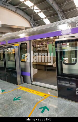 Der U-Bahn-Zug hält an einem Bahnhof und öffnet die Tür, um zu warten, bis Passagiere während der Hauptverkehrszeit an der U-Bahn-Station Kolkata East West einsteigen Stockfoto