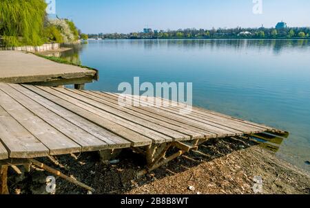 Ein alter Holzrutsch, Bootsrampe an einem sonnigen Tag. Abgenutzter Bootsanleger am Seeufer. Stockfoto