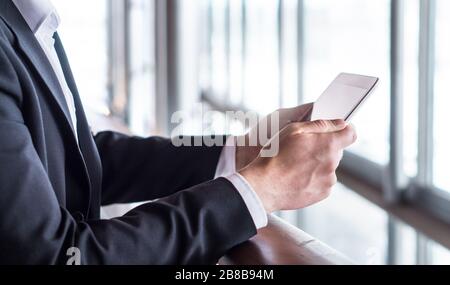 Business man verwendet Tablet oder liest Nachrichten mit Tablet. Geschäftsmann, der in einem modernen Bürogebäude mit intelligentem Mobilgerät arbeitet. Stockfoto