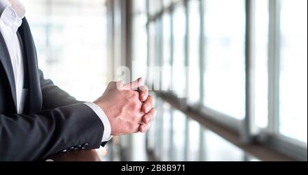 Business man denkt und schaut aus dem Fenster. Nahaufnahme der gelehnten Hände. Stockfoto