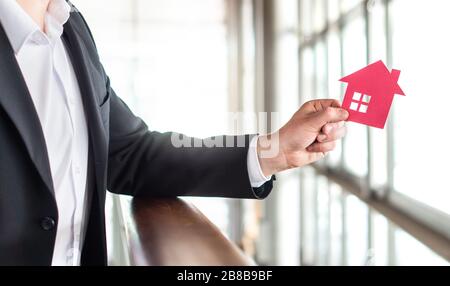 Architekt, Banker, Realtor, Agent, Geschäftsmann oder Makler, der ein Papierhaus hält. Immobilien- oder Architekturgeschäft. Mietwohnung, Hypothek. Stockfoto