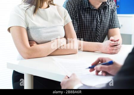 Unglückliches Paar bei Treffen mit Therapeut, Psychologe, Scheidungsanwalt oder Rechtsberater. Verärgerte Frau und Mann, die in der Therapiesitzung kämpfen. Stockfoto