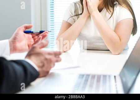 Junge Frau wird von der Arbeit im Büro gefeuert. Der Chef beschwert sich oder gibt unzufriedenen Mitarbeiter negatives Feedback. Trauriger Bewerber. Stockfoto