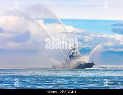 Das schwimmende Schleppboot sprüht Wasserstrahlen Stockfoto