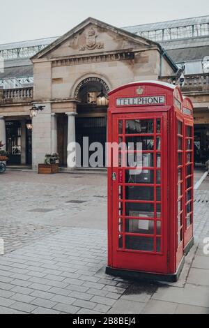 London, Großbritannien - 06. März 2020: Rote Telefonbox Covent Garden, Markt im Hintergrund. Rote Telefonboxen sind in aktuellen oder ehemaligen britischen Kolonien zu finden Stockfoto