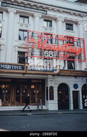 London, Großbritannien - 06. März 2020: Mann, der an Mousetrap Neon-Zeichen an der Fassade des St Martins Theatre in London, der Heimat der berühmten Agatha Christies p, vorbeigeht Stockfoto
