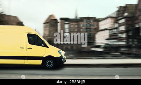 Schnelle Paketzustellung, Gelber Postwagen in einer historischen Kleinstadt. Stockfoto