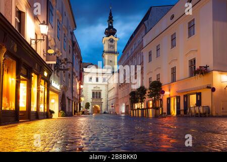 Linz, Österreich. Stadtbild der Altstadt Linz, Österreich in dämmerungsblauer Stunde mit Reflexion der Stadtlichter Stockfoto