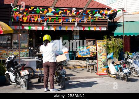NAKHON PATHOM, THAILAND - 26. NOVEMBER: Thailändische Frauen Lieferung von Lebensmittelgetränken Versand von Produkten an Kunden Tha Na lokaler und alter Markt in Nakhon Chai Si ci Stockfoto
