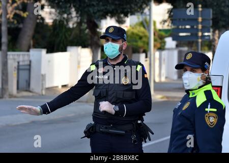 Vendrell, Spanien. März 2020. Ein Polizeibeamter, der eine Gesichtsmaske und chirurgische Handschuhe als Vorsichtsmaßnahme gegen die Ausbreitung von Coronavirus an einem Polizeikontrollpunkt trägt, hält ein Fahrzeug an.die örtliche Polizei in El Vendrell verhindert, dass Menschen aus anderen Städten in ihre Wohnung im Strandbereich kommen, um die Ausbreitung des zu verhindern Covid-19 Coronavirus. El Vendrell ist eine Stadt, die mit der Ankunft der Wochenenden im Frühling und Sommer ihre Bevölkerung durch die Wohnungen im Strandbereich verdoppelt, die im Besitz von Menschen aus anderen Städten sind. Credit: SOPA Images Limited/Alamy Live News Stockfoto