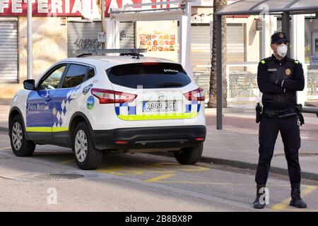 Vendrell, Spanien. März 2020. Ein Polizeibeamter, der eine Gesichtsmaske und chirurgische Handschuhe als Vorsichtsmaßnahme gegen die Ausbreitung von Coronavirus trägt, steht an einem Polizeikontrollpunkt.die örtliche Polizei in El Vendrell verhindert, dass Menschen aus anderen Städten zu ihrer Wohnung im Strandbereich kommen, um die Ausbreitung des Covid-19 Coronavirus zu verhindern. El Vendrell ist eine Stadt, die mit der Ankunft der Wochenenden im Frühling und Sommer ihre Bevölkerung durch die Wohnungen im Strandbereich verdoppelt, die im Besitz von Menschen aus anderen Städten sind. Credit: SOPA Images Limited/Alamy Live News Stockfoto