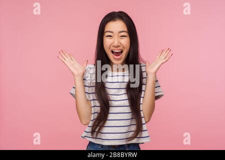 Wow, ich habe gewonnen! Porträt des überraschten glücklichen Mädchens mit langen Haaren im gestreiften T-Shirt, das verblüffend schreit, schockiert aussehend und freudig unerwarteter Sieger ist Stockfoto