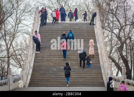 Touristen auf der Jade Belt Bridge an einem Kunming-See im Sommerpalast, ehemaliger imperialer Garten in Peking, China Stockfoto