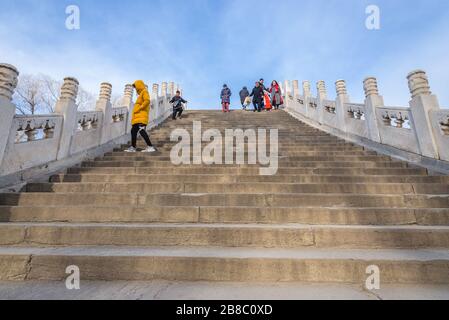 Touristen auf der Jade Belt Bridge an einem Kunming-See im Sommerpalast, ehemaliger imperialer Garten in Peking, China Stockfoto