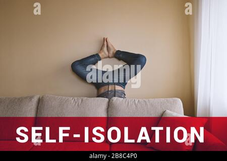 Mann, der hinter beigefarbener Couch steht und Yoga macht. Selbstisolation während der Quarantäne des Coronavirus Kovid 19 Stockfoto