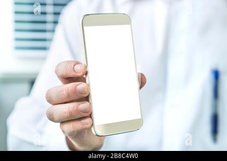 Arzt hält Smartphone mit leerem weißen Bildschirm. Medizinisches Fachpersonal, Arzt, Krankenschwester oder Zahnärztin, das Handy mit Kopierraum zeigt. Stockfoto