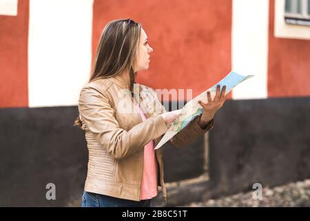 Frau liest Karte und plant Route zum Ziel. In der Stadt verloren. Touristennavigation in der Altstadt. Reisekonzept. Stockfoto