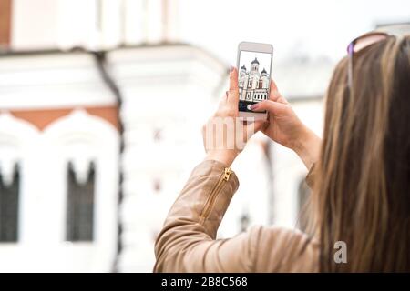 Junge Frau in Tallinn, Estland, fotografieren mit Smartphone die Alexander-Newski-Kathedrale in der Altstadt. Reisefotografie mit Handy. Stockfoto