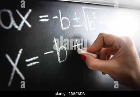 Mathematische Gleichung, Funktion oder Berechnung auf dem Schwarzen Brett. Lehrer, der während des Unterrichts und des Vortrags im Schulunterricht an der Tafel schreibt. Stockfoto