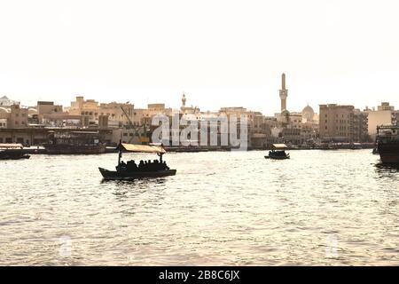 Dubai Creek mit Abra-Booten. Einheimische und Touristen benutzen Wassertaxi und Fähren im Fluss Altstadt. Traditionelle Bootstour. Malerischer Blick auf die arabische Stadt. Stockfoto