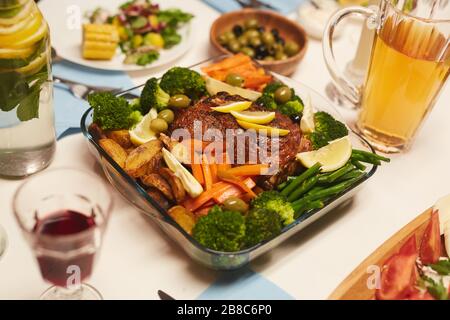 Bild von Bratfleisch mit Kartoffeln und Gemüse, das zum Abendessen auf dem Tisch serviert wird Stockfoto