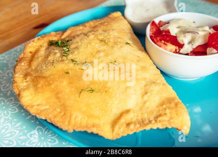 Cheburek - frittierter Umsatz mit einer Füllung aus Hackfleisch und Zwiebeln, Nationalgericht der krimtatarischen Küche Stockfoto