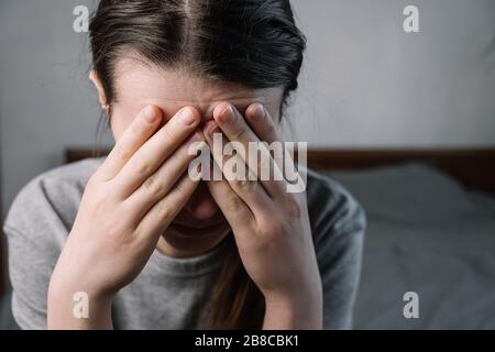 Nahaufnahmen von nachdenklich unsicheren jungen Frauen, die die Stirn berühren und Kopfschmerzen Migräne oder Depressionen haben, betonte frustrierte ängstliche Dame, die zweifelt Stockfoto