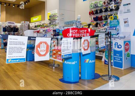 Coronavirus Warnschilder und Sicherheitsbarrieren in einer Amcal Apotheke am internationalen Abflugterminal des Flughafens Sydney (Kingsford Smith) in Australien. Der Chemiker hatte die Barriere und Warnungen am Ladeneingang platziert, um Flugpassagiere, die gerade nach Australien gekommen waren, zu bitten, sich an "soziale Distanzierungsregeln" zu halten, um das Risiko einer Verbreitung des Coronavirus zu verringern. Stockfoto