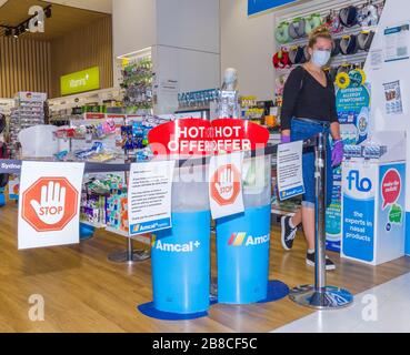 Coronavirus Warnschilder und Sicherheitsbarrieren in einer Amcal Apotheke am internationalen Abflugterminal des Flughafens Sydney (Kingsford Smith) in Australien. Der Chemiker hatte die Barriere und Warnungen am Ladeneingang platziert, um Flugpassagiere, die gerade nach Australien gekommen waren, zu bitten, sich an "soziale Distanzierungsregeln" zu halten, um das Risiko einer Verbreitung des Coronavirus zu verringern. Stockfoto