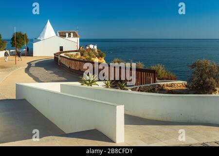Blick auf die Ermida da Nossa Senhora da Rocha, in der Algarve-Region im Süden Portugals, mit dem Meer als Hintergrund, an einem heißen und sonnigen Tag Durin Stockfoto