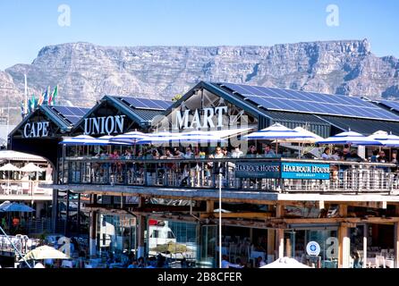 Die Terrasse des Harbour House Restaurants ist voll und liegt direkt vor dem Outdoor-Händler Cape Union Mart, der über dem Tafelberg thront Stockfoto