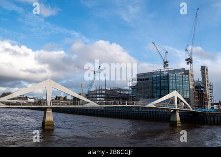 Die Squiggly Bridge, die sonst als Tradeston Bridge bekannt ist, mit der neuen Buchanan Wharf Entwicklung im Hintergrund Stockfoto